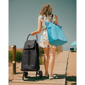 une femme à la plage avec un chariot Rolser Imax 2 roues